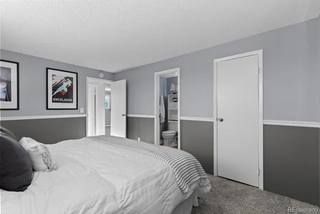 a bedroom with a large bed and a painting on the wall