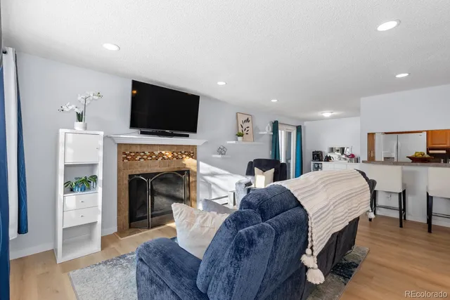 a living room with furniture a flat screen tv and a fireplace