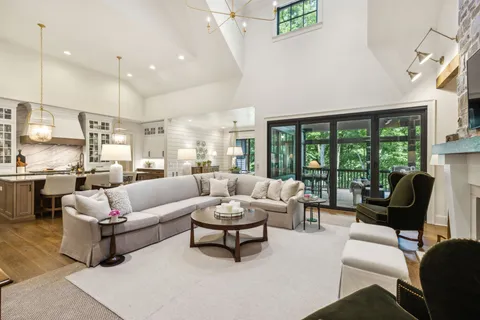 a large white kitchen with a large island oven a stove and a wooden floors
