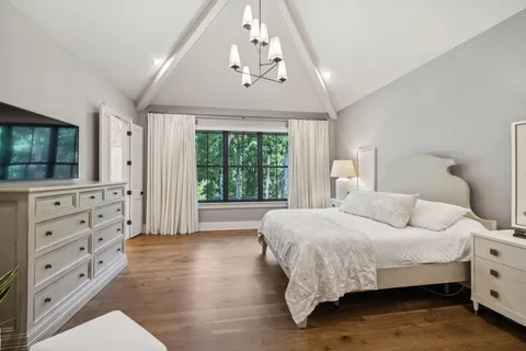 a bedroom with a bed and glass walk in closet