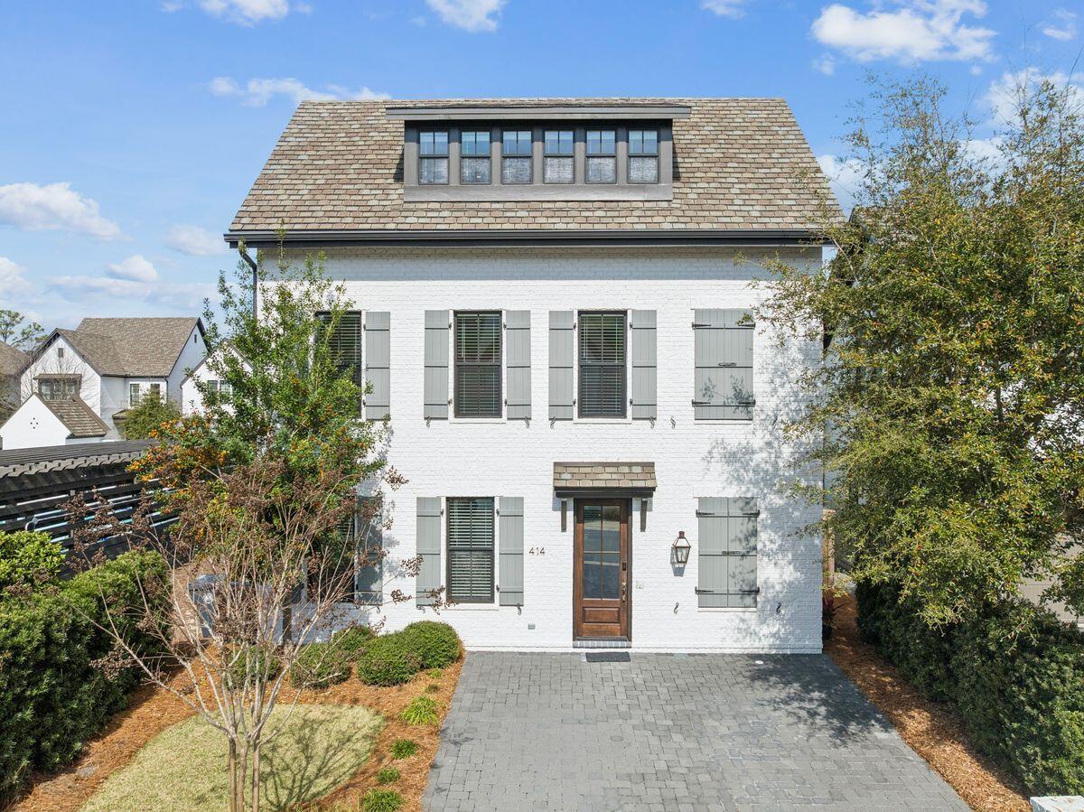 a front view of a house with plants