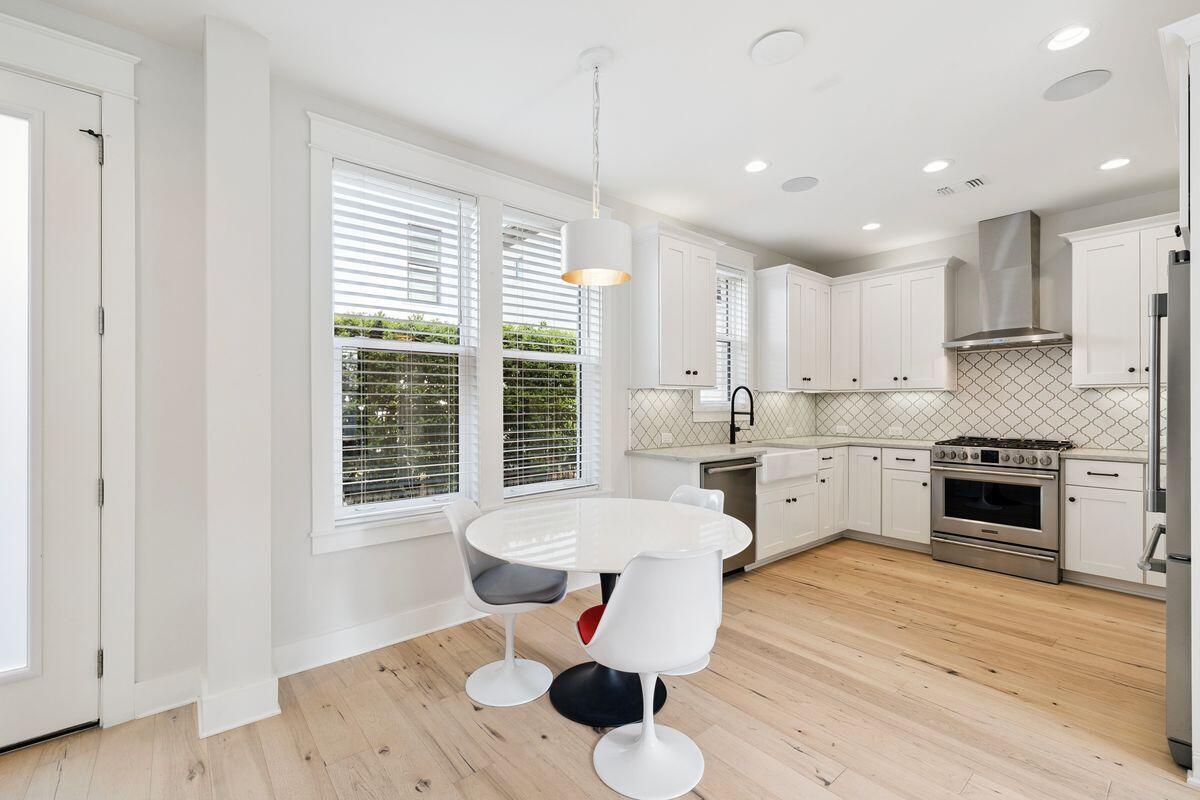 414 Ridgewalk Circle Santa Rosa Beach, FL 32459 - Photo 9 of 47 a open kitchen with stainless steel appliances granite countertop a stove a sink and white cabinets with wooden floor