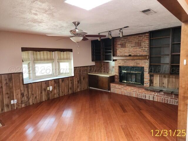 3401 Sunlite Street Amarillo, TX 79109 - Photo 8 of 26 an empty room with wooden floor fireplace and windows