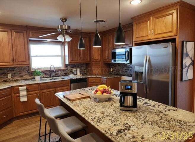 3401 Sunlite Street Amarillo, TX 79109 - Photo 9 of 26 a kitchen with stainless steel appliances granite countertop a sink a stove and refrigerator