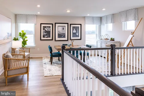a view of a hallway with wooden floor and furniture