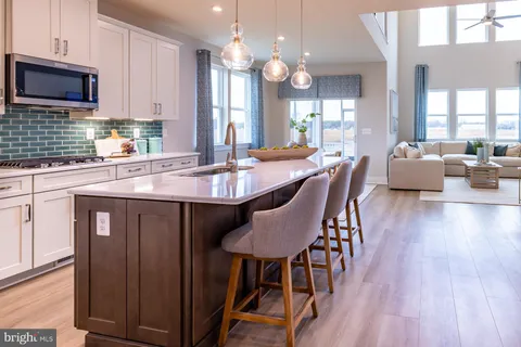 a large kitchen with kitchen island a dining table chairs and a wooden floor