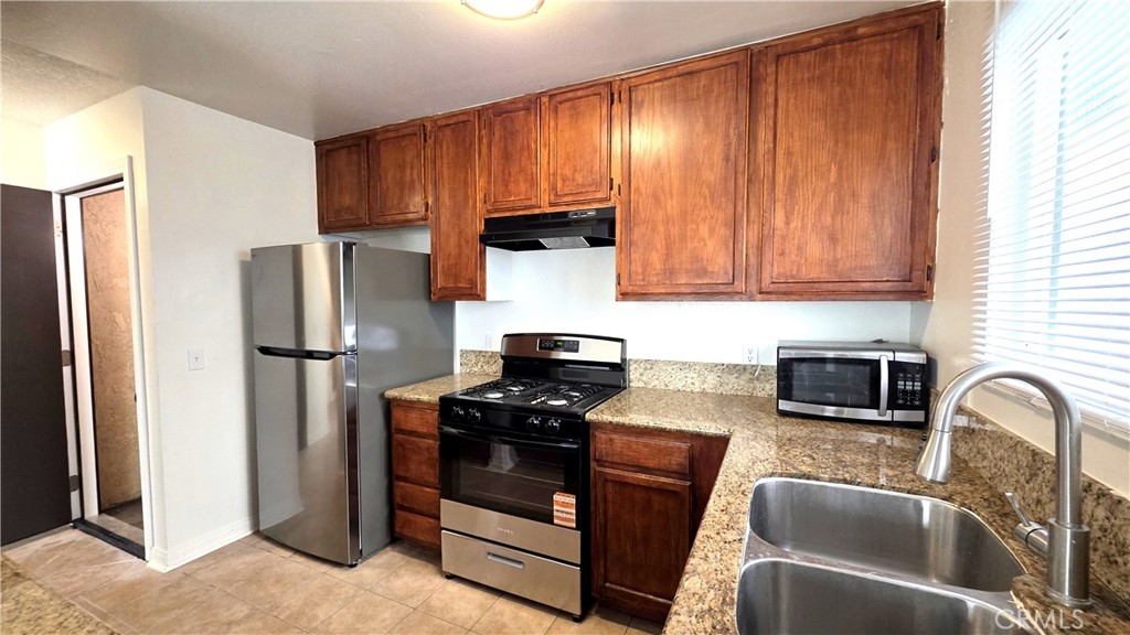 7331 9th Street, Unit 2 Buena Park, CA 90621 - Photo 4 of 19 a kitchen with stainless steel appliances granite countertop a refrigerator stove and sink