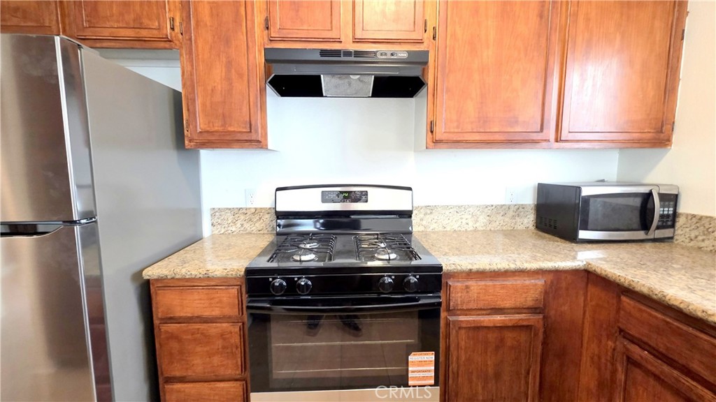7331 9th Street, Unit 2 Buena Park, CA 90621 - Photo 7 of 19 a kitchen with stainless steel appliances granite countertop a stove and a microwave