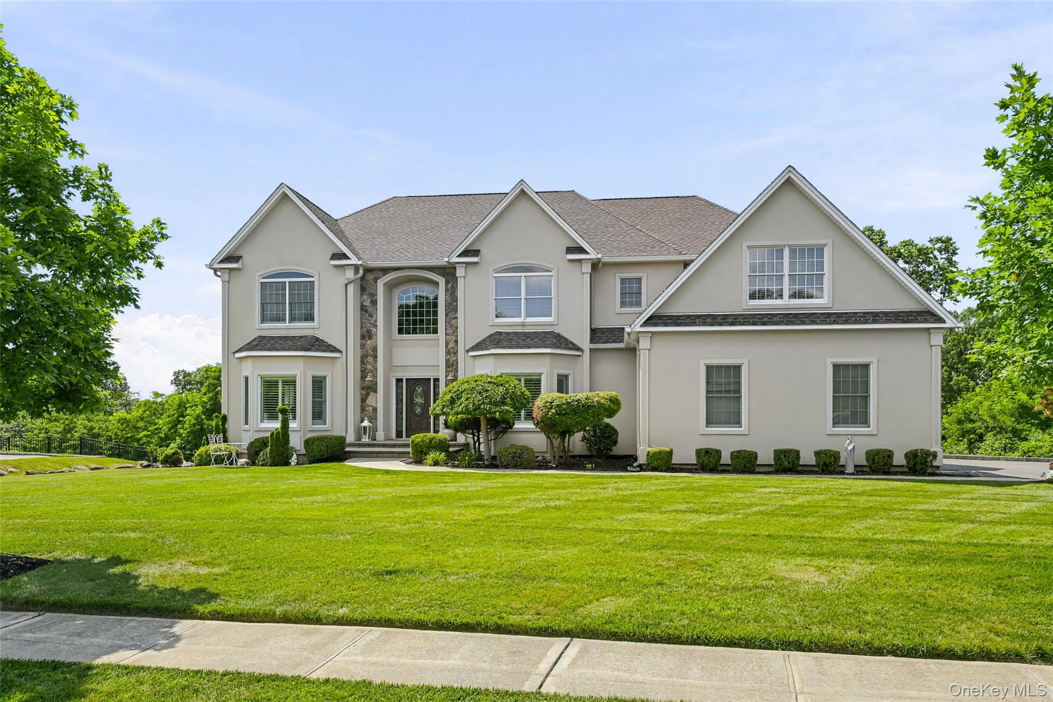 51 Meriwether Trail Congers, NY 10920 - Photo 1 of 50 Stately two-story residence featuring a bay window, a prominent entry with a dark door, multiple windows, a sidewalk, and a manicured lawn
