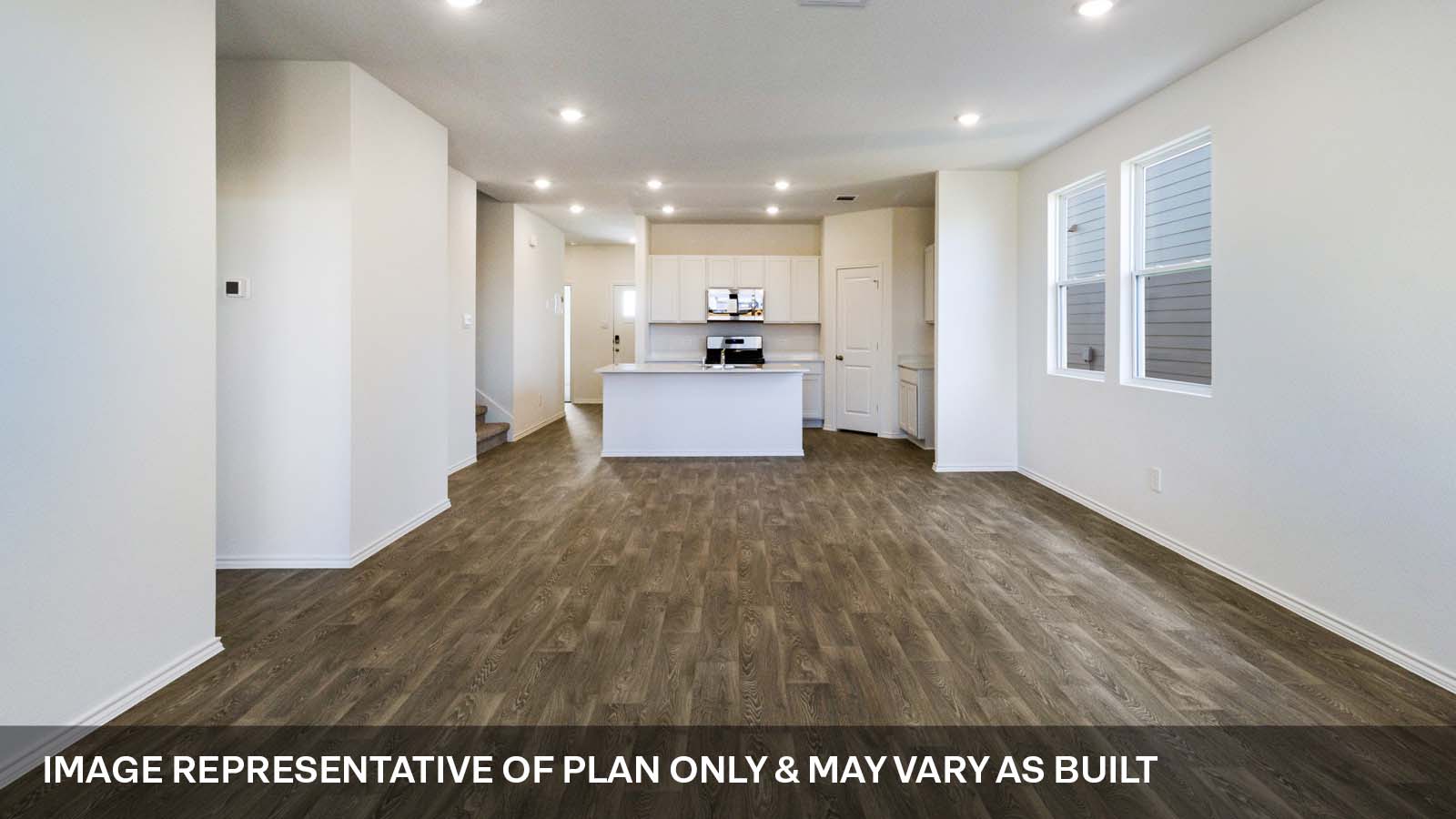 1173 Celosia Loop Kyle, TX 78640 - Photo 7 of 15 a view of a kitchen with kitchen island a sink wooden floor and a large window