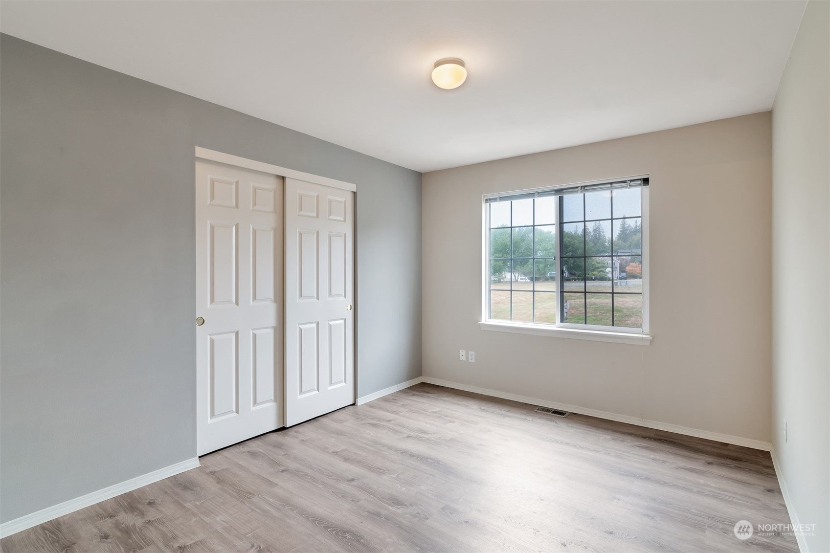 13197 Icicle Ridge Road Southeast Monroe, WA 98272 - Photo 17 of 25 an empty room with wooden floor and windows
