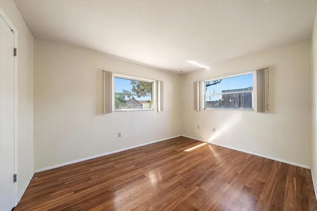 a view of empty room with wooden floor