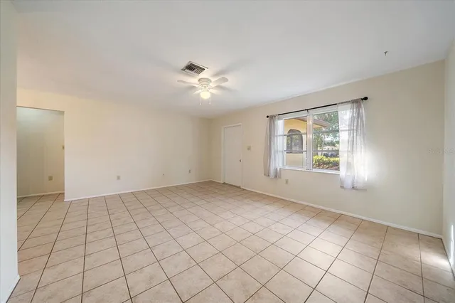 an empty room with windows and fan