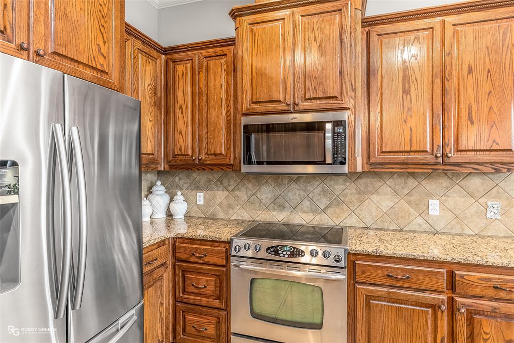 425 Kingston Road Benton, LA 71006 - Photo 15 of 35 a kitchen with stainless steel appliances wooden cabinets and a stove top oven