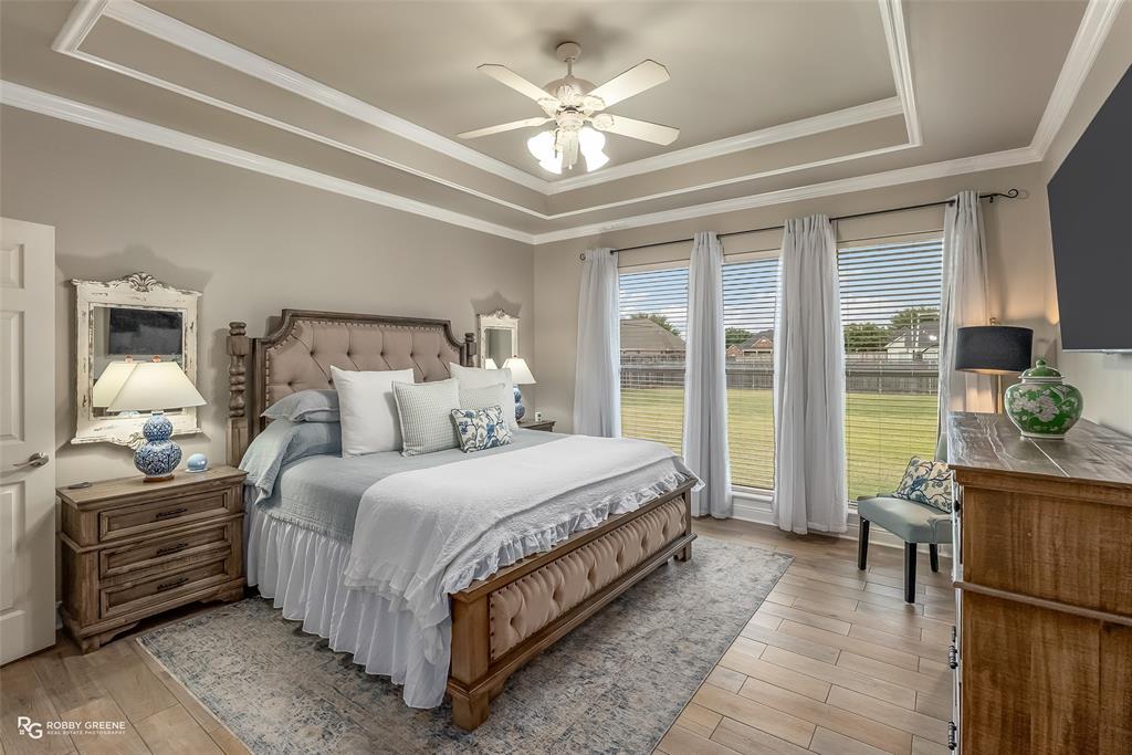 425 Kingston Road Benton, LA 71006 - Photo 17 of 35 a spacious bedroom with a bed a chandelier and a large window