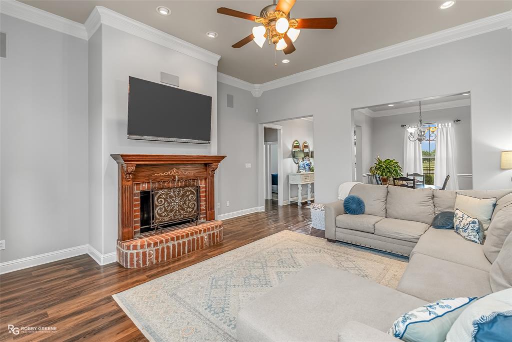 425 Kingston Road Benton, LA 71006 - Photo 7 of 35 a living room with furniture a flat screen tv and a fireplace
