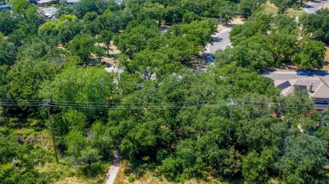 an aerial view of residential house with outdoor space and trees all around