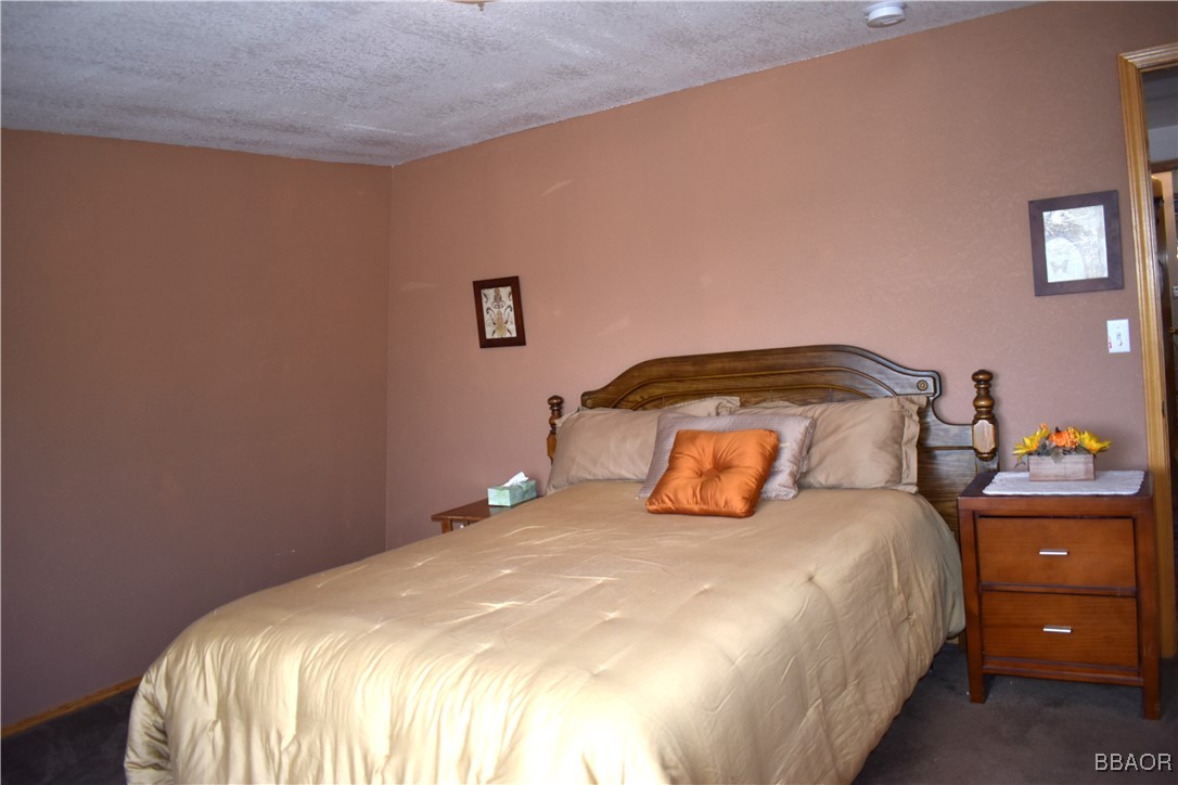442 Inyo Avenue Sugarloaf, CA 92386 - Photo 21 of 36 a bedroom with a bed and a lamp