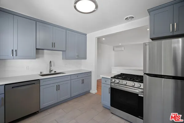 a kitchen with cabinets appliances and a sink