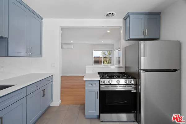 a kitchen with white cabinets and white stainless steel appliances