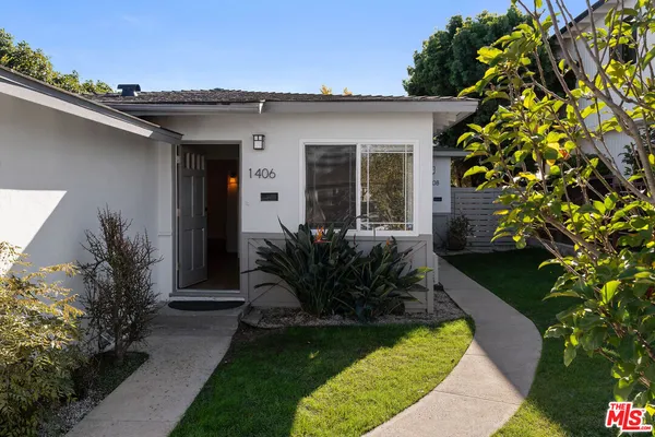 a view of a house with a small yard plants and a lawn chair