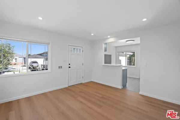 a view of a kitchen with wooden floor and a window