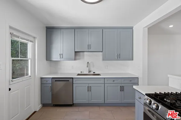 a kitchen with stainless steel appliances granite countertop a sink stove and cabinets