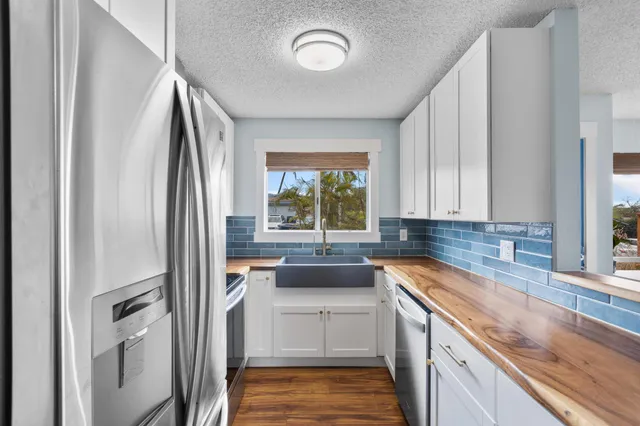 a view of a kitchen with granite countertop a sink and a window