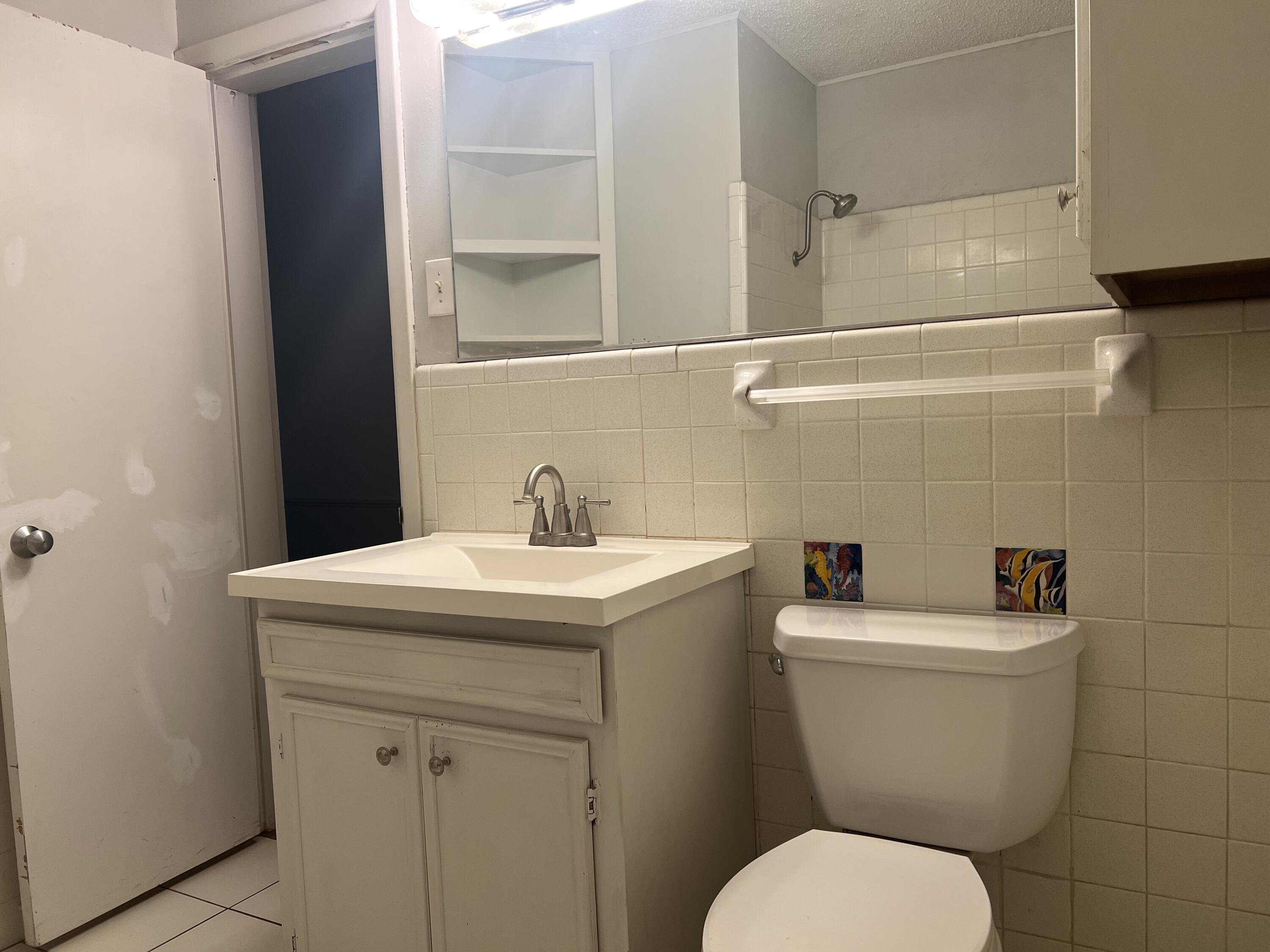2424 33rd Street Lubbock, TX 79411 - Photo 20 of 23 a bathroom with a toilet sink and mirror