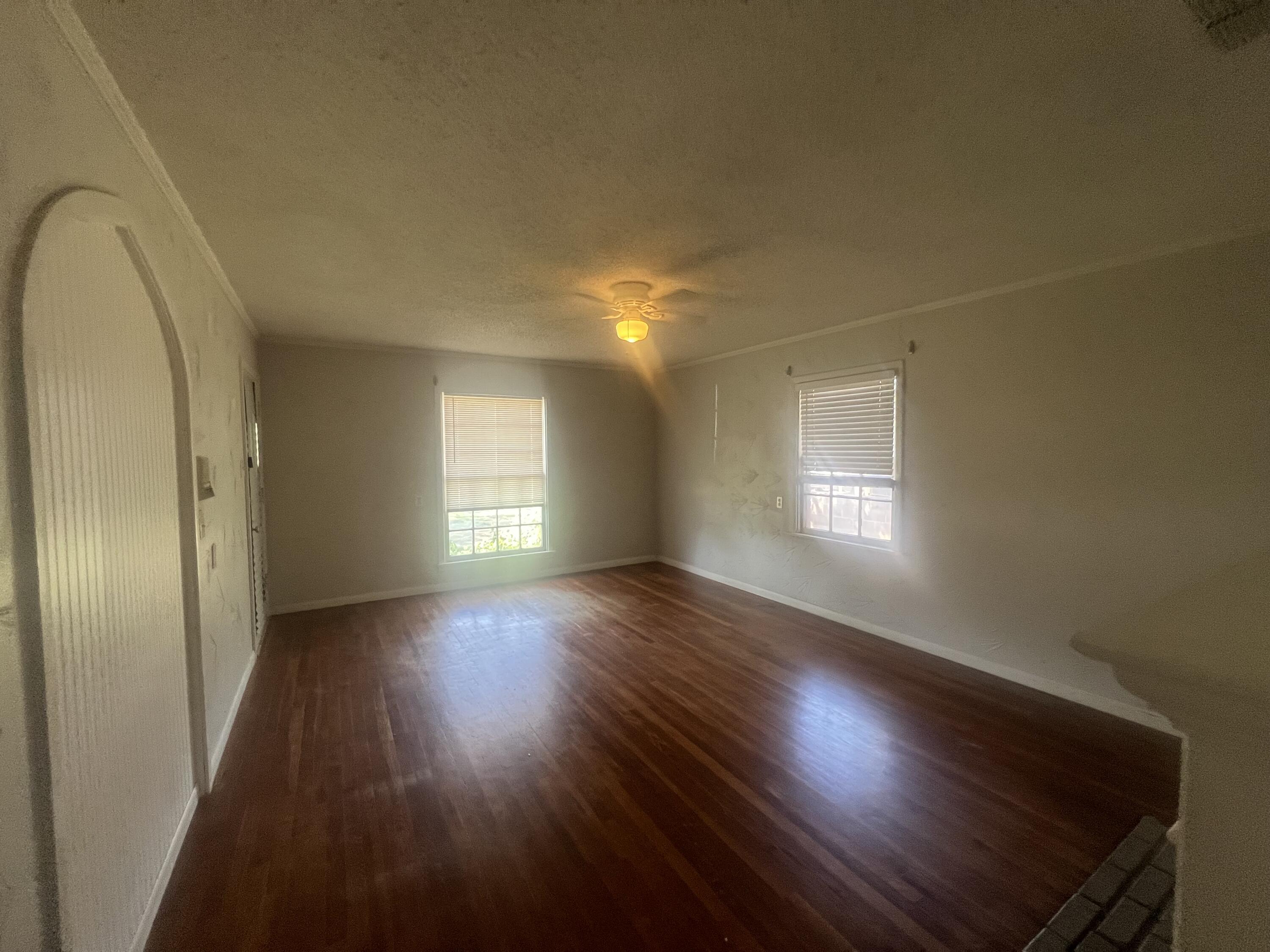 2424 33rd Street Lubbock, TX 79411 - Photo 9 of 23 an empty room with wooden floor and windows
