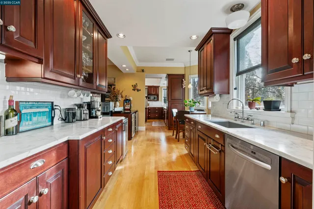 a view of a dining room with furniture a rug and wooden floor