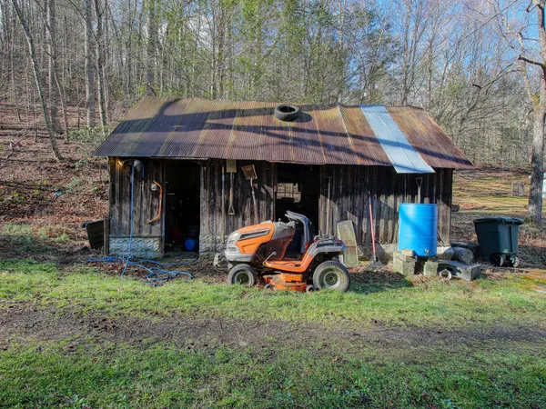 a view of a wooden house with a large tree