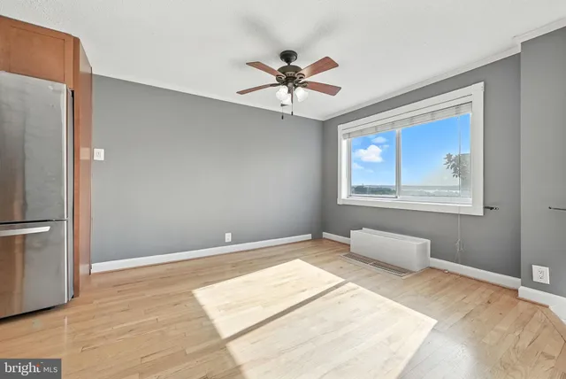 a view of an empty room with window and a ceiling fan