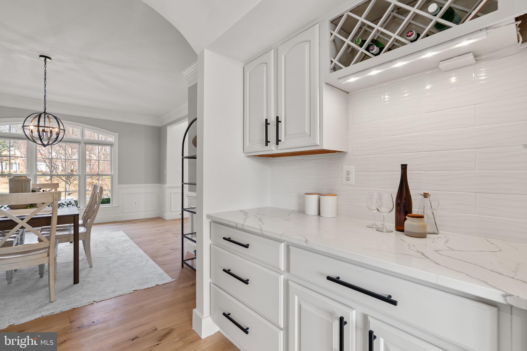 25114 Vista Ridge Road Laytonsville, MD 20882 - Photo 25 of 97 a kitchen with stainless steel appliances kitchen island granite countertop a stove a sink and white cabinets with wooden floor
