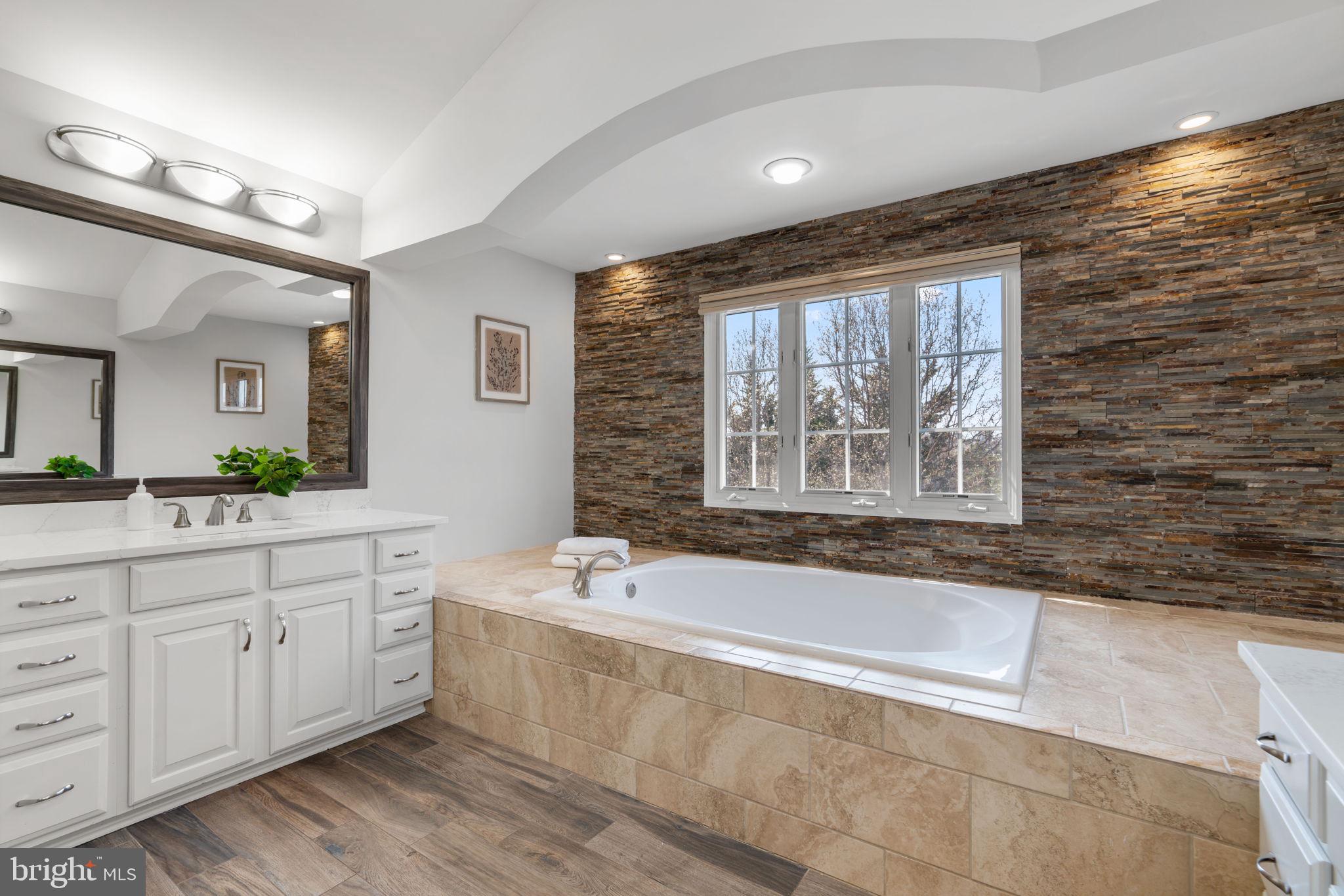 25114 Vista Ridge Road Laytonsville, MD 20882 - Photo 42 of 97 a spacious bathroom with a tub a sink and mirror