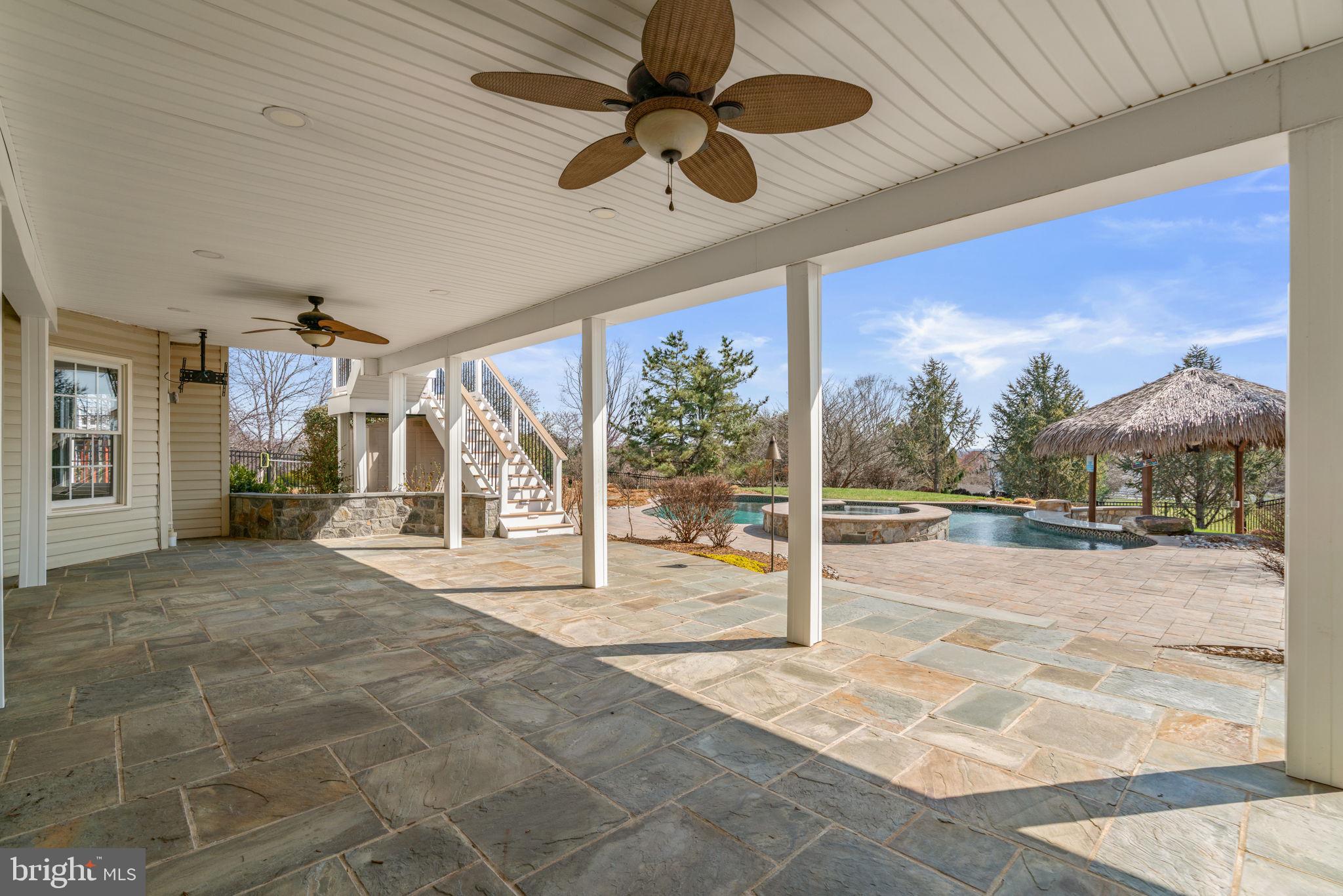 25114 Vista Ridge Road Laytonsville, MD 20882 - Photo 75 of 97 a view of a hall with floor to ceiling windows and a ceiling fan