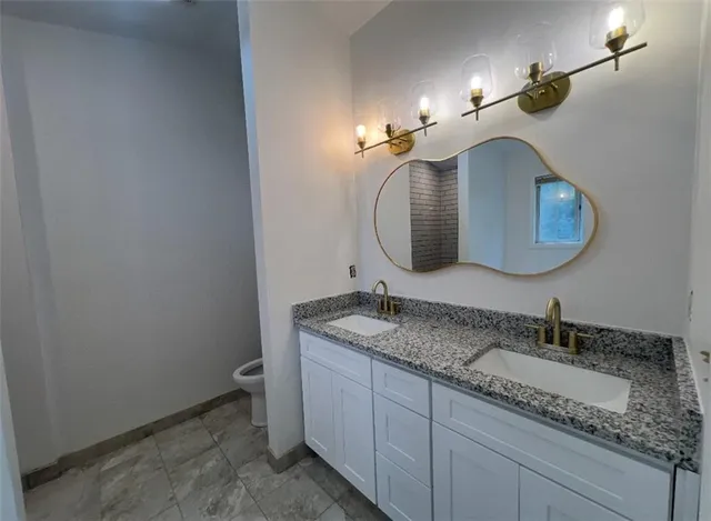 a bathroom with a granite countertop sink and a mirror