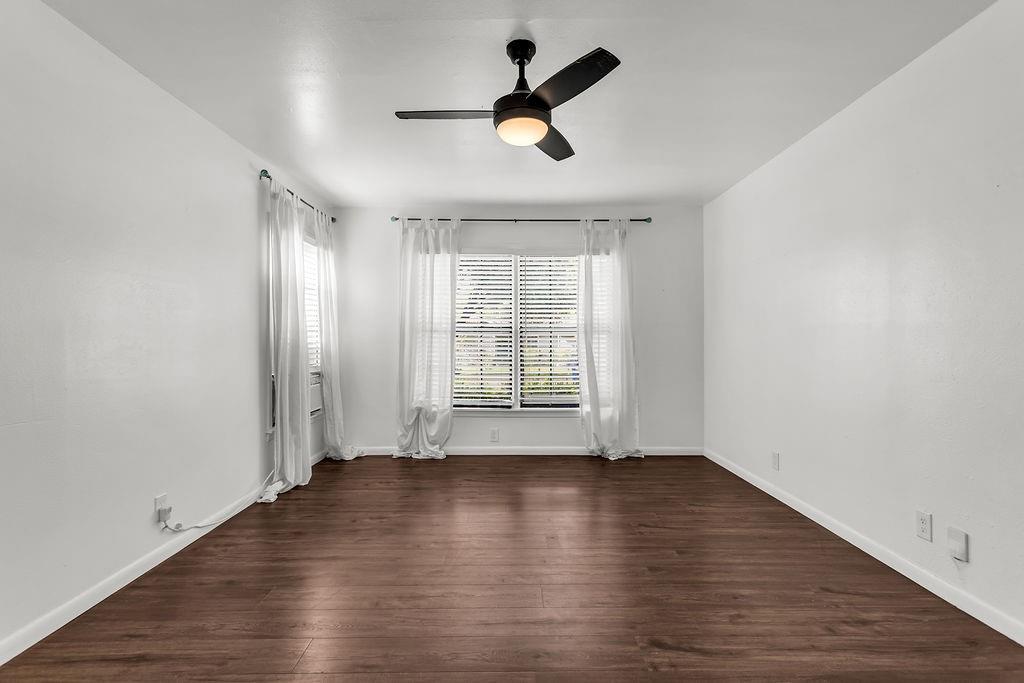 9440 Magnolia Road Frisco, TX 75033 - Photo 13 of 29 an empty room with wooden floor ceiling fan and windows