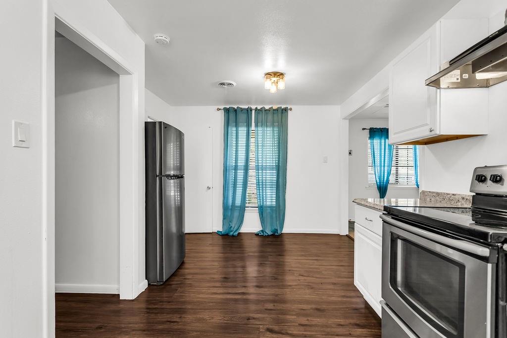 9440 Magnolia Road Frisco, TX 75033 - Photo 4 of 29 a kitchen with stainless steel appliances granite countertop a refrigerator a stove and a wooden floors