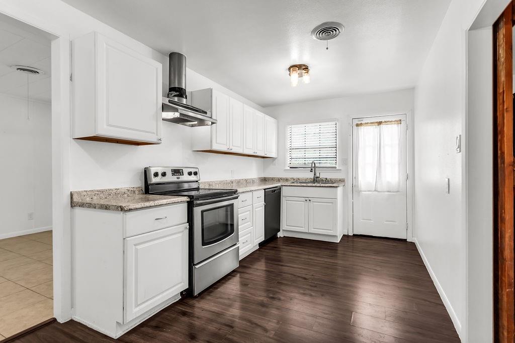 9440 Magnolia Road Frisco, TX 75033 - Photo 8 of 29 a kitchen with granite countertop wooden floors and white stainless steel appliances