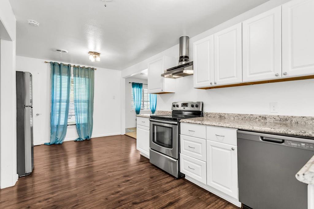 9440 Magnolia Road Frisco, TX 75033 - Photo 9 of 29 a kitchen with stainless steel appliances granite countertop a stove a sink and white cabinets