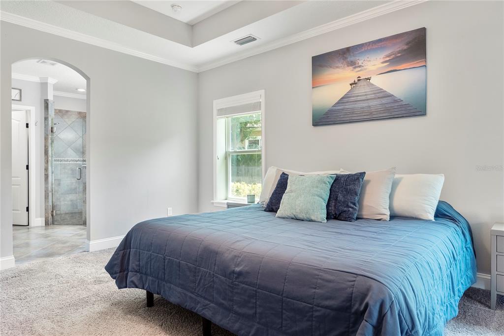 265 Pinehurst Pointe Drive St. Augustine, FL 32092 - Photo 30 of 66 a bedroom with a large bed and a painting on the wall