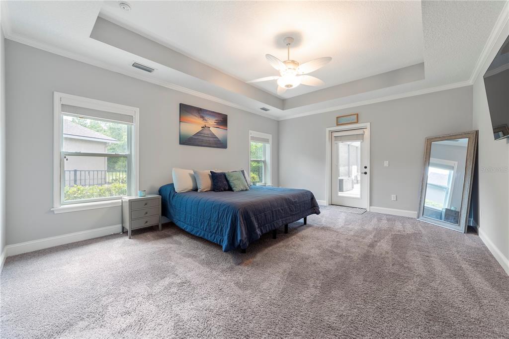 265 Pinehurst Pointe Drive St. Augustine, FL 32092 - Photo 31 of 66 a spacious bedroom with a bed and a chandelier