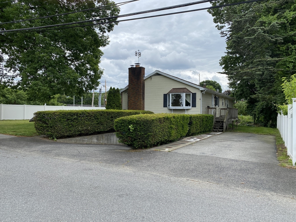 a view of a house with a yard and large trees