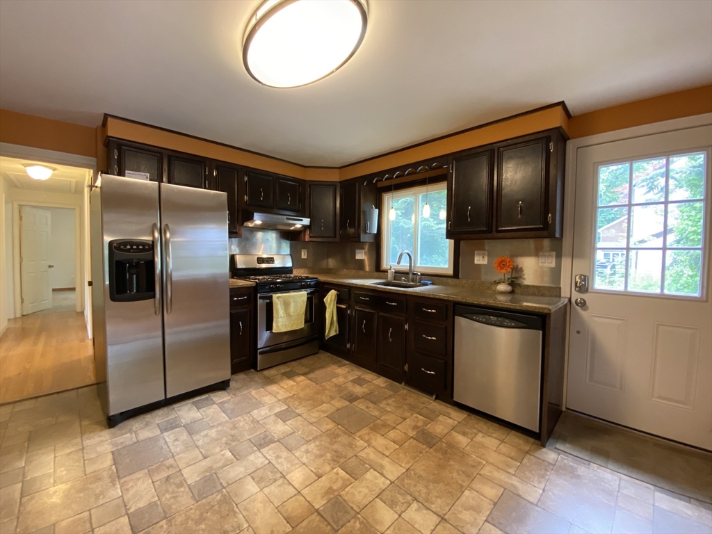2 Travis Road Natick, MA 01760 - Photo 6 of 18 a kitchen with granite countertop a refrigerator and a stove top oven