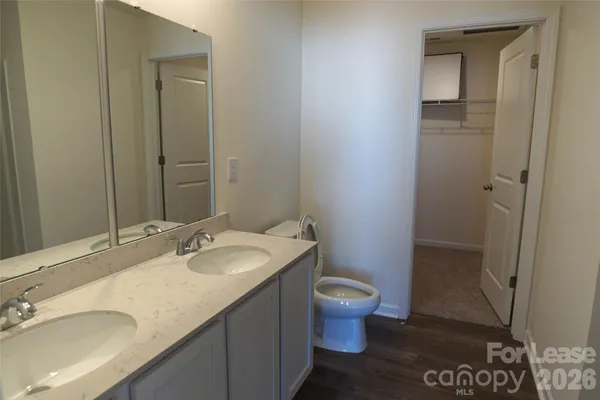 a bathroom with a granite countertop sink a toilet and a mirror