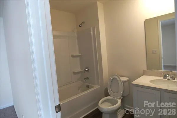 a bathroom with a granite countertop toilet a sink and a bathtub