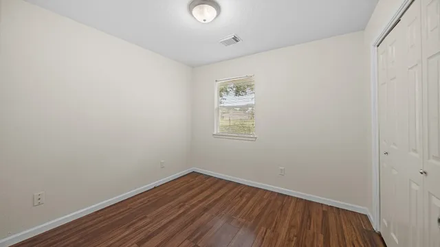 a view of a room with wooden floor and white walls
