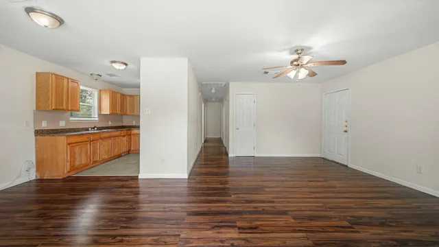 a view of kitchen with granite countertop stainless steel appliances and wooden floor