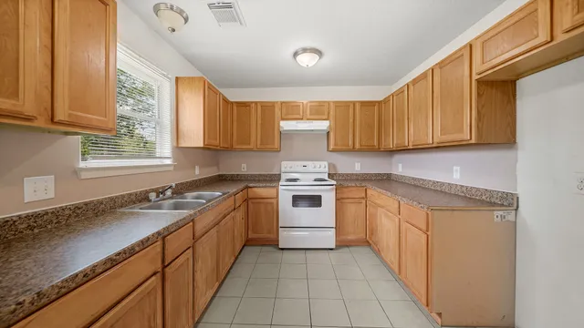 a kitchen with a sink stove and cabinets